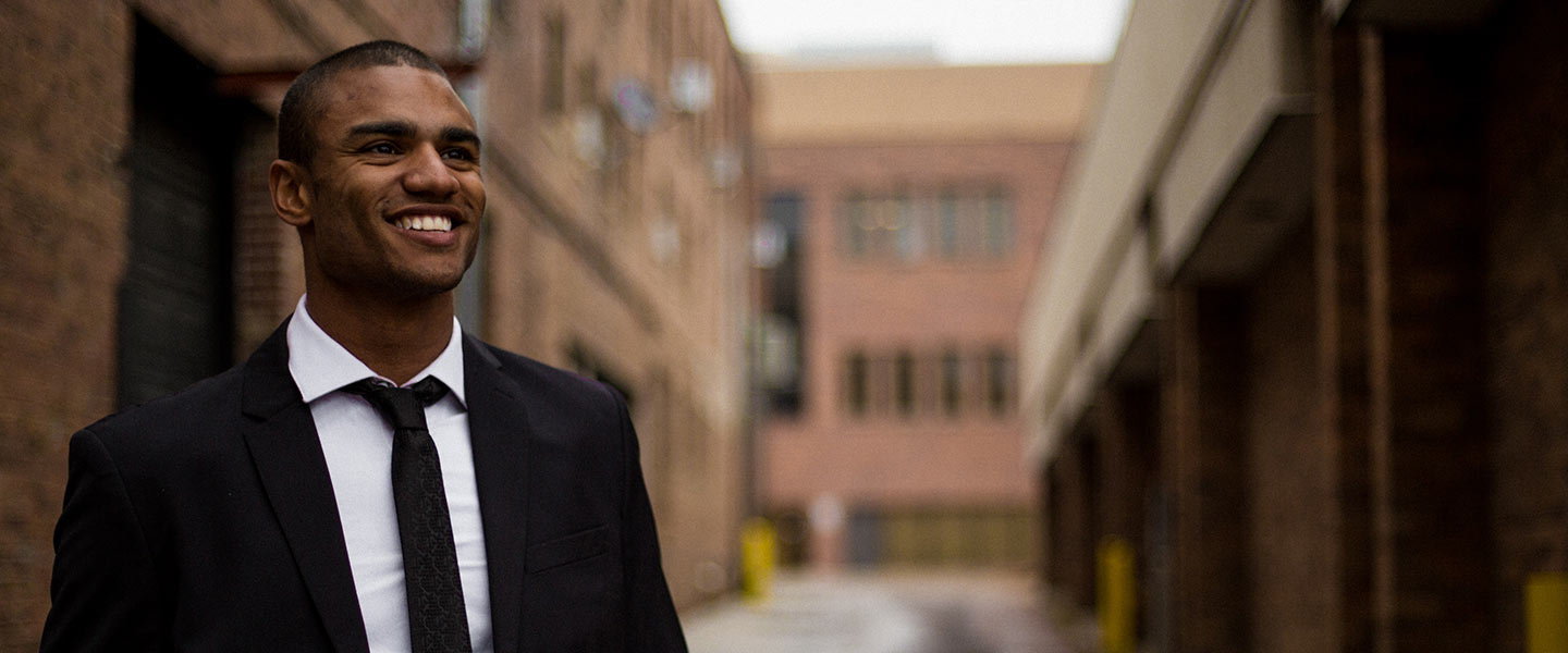 Man smiling for a photo with buildings in background