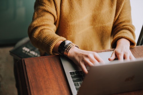 Man viewing laptop screen and typing