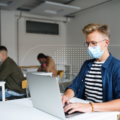 Man wearing mask, typing, posing for photo