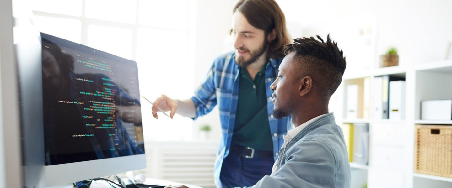 Man explaining, pointing at Mac