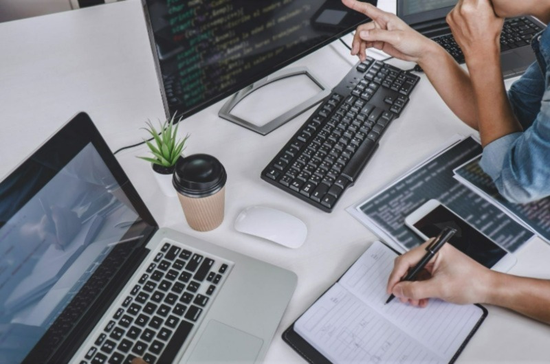 Two People Working: One Showing, One Noting