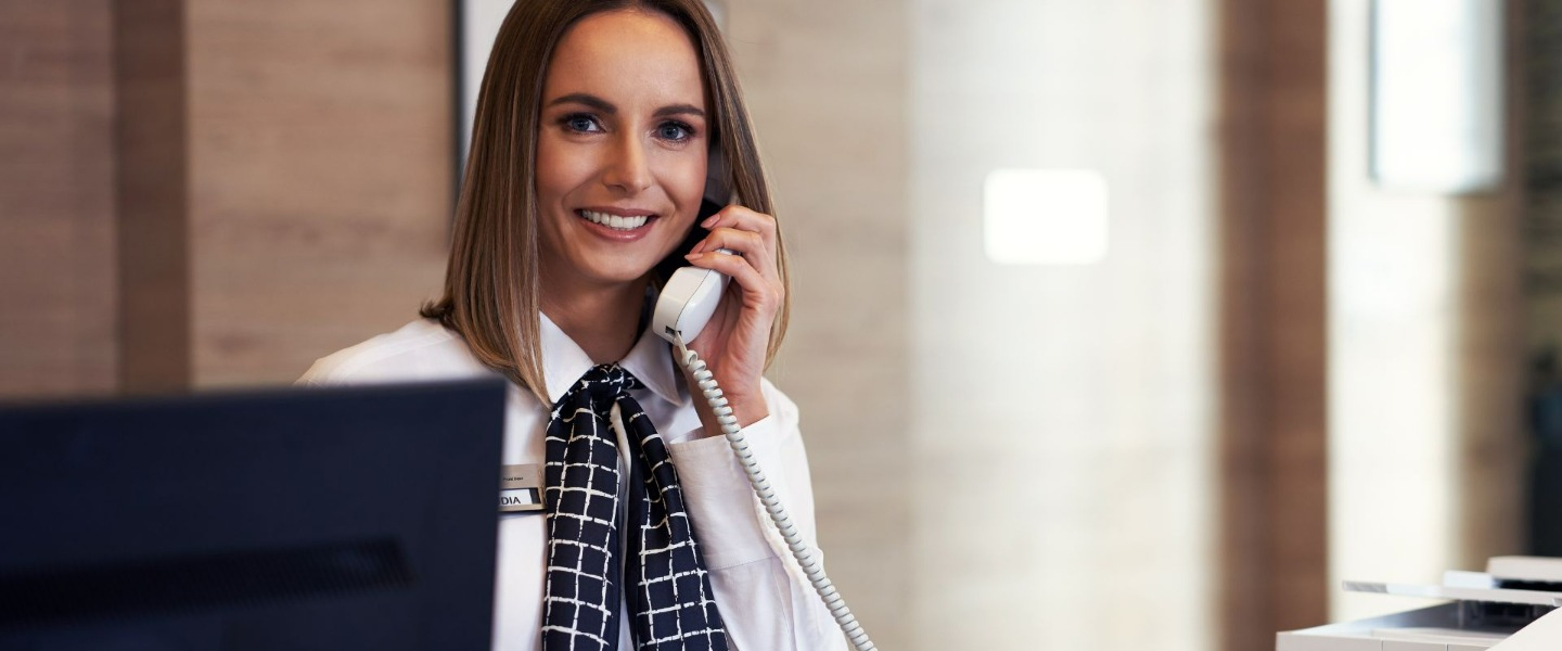 Woman talking on phone, smiling, and posing for a photo