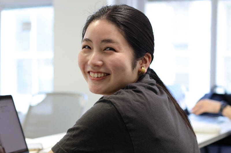 Woman typing, smiling for photo